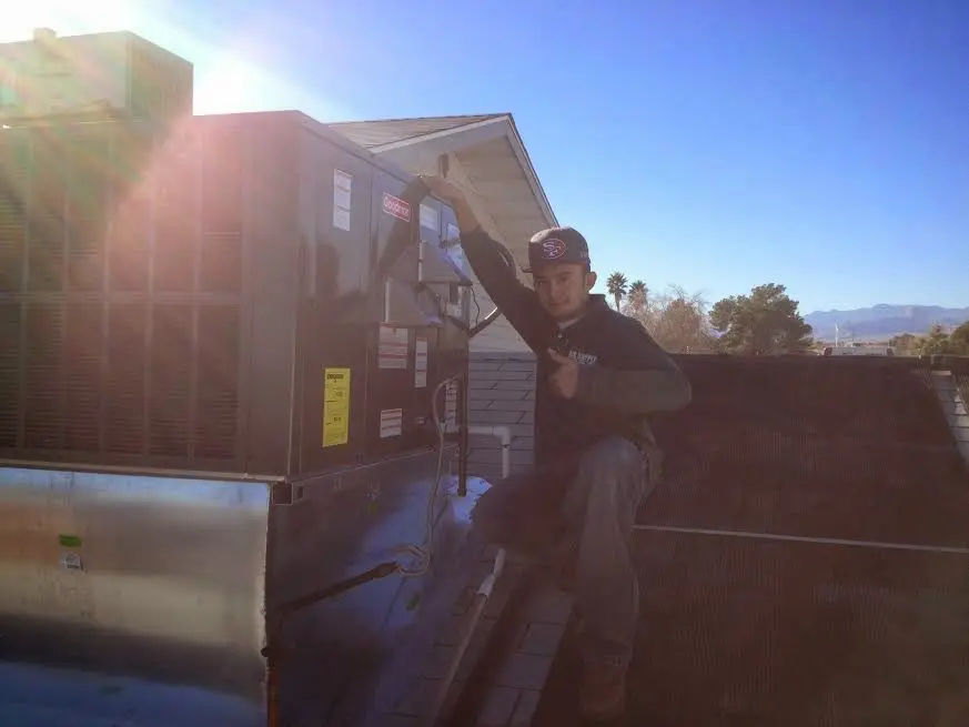 HVAC technician performing Boiler Repair on a rooftop unit in Langley Park